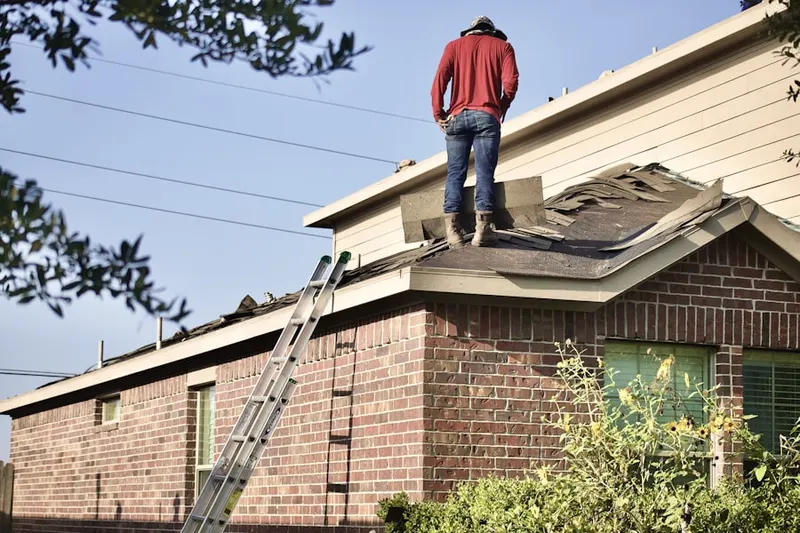 Professional roofer working on a residential roof in Shoemaker